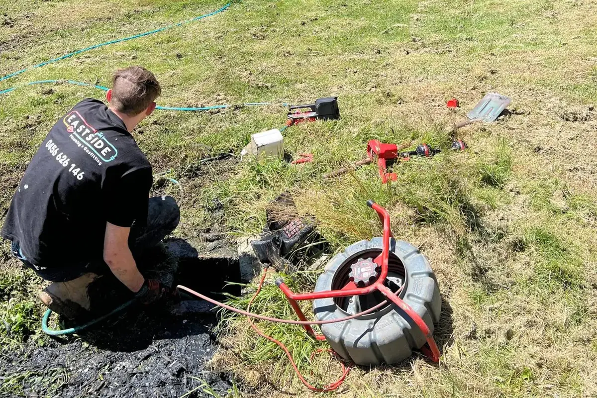 Technician feeding a drain camera into an outdoor access point